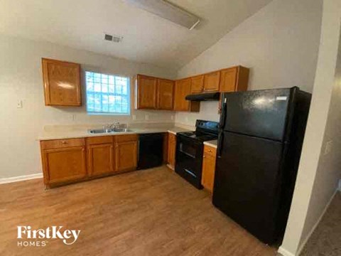 A kitchen with wooden cabinets and black appliances.