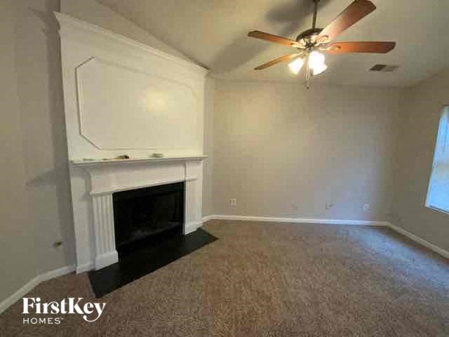 A room with a fireplace and a ceiling fan.