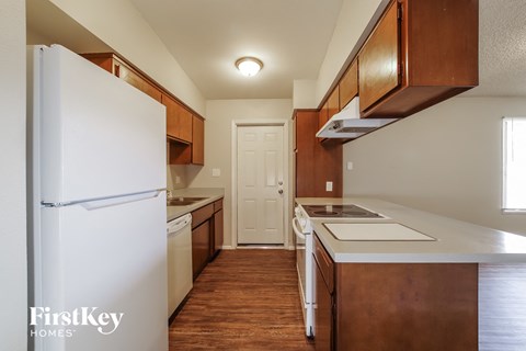 a kitchen with white appliances and wooden cabinets and a refrigerator