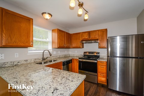 A kitchen with wooden cabinets and granite countertops.