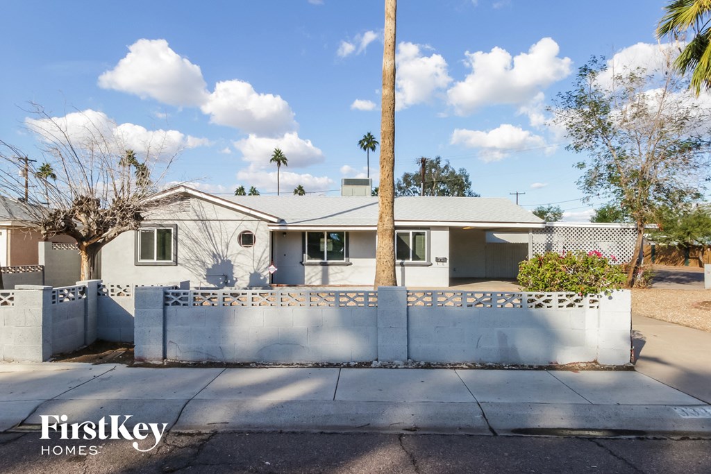 a white house with a white fence and palm trees