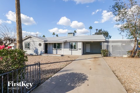 a white house with a driveway and a fence
