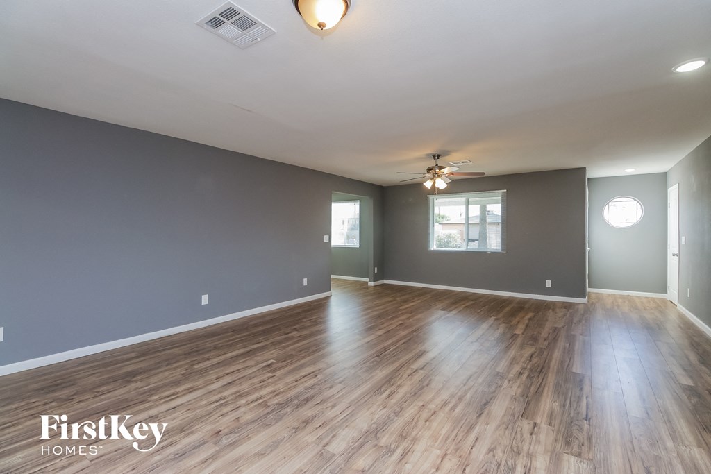 the living room and dining room with hardwood floors and grey walls