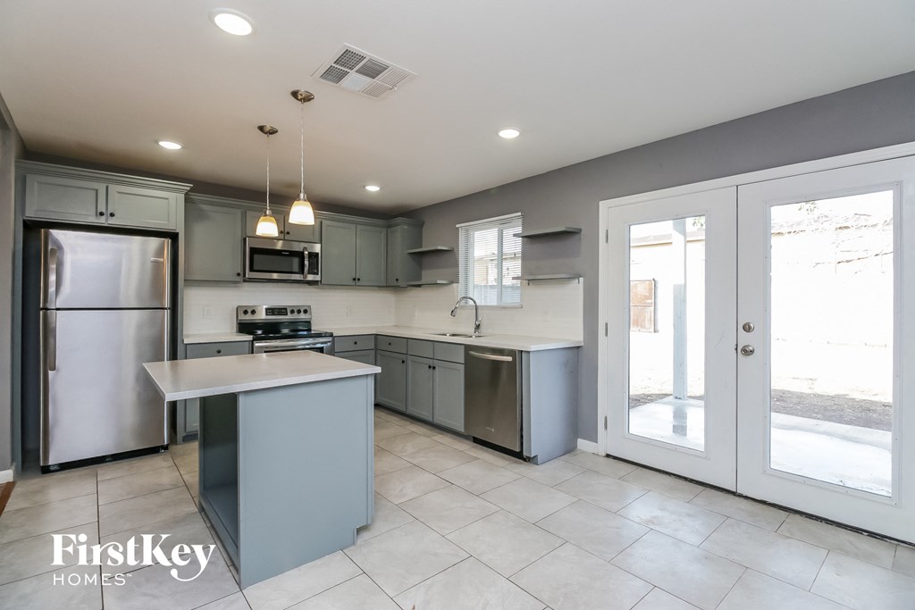 a modern kitchen with stainless steel appliances and gray cabinets