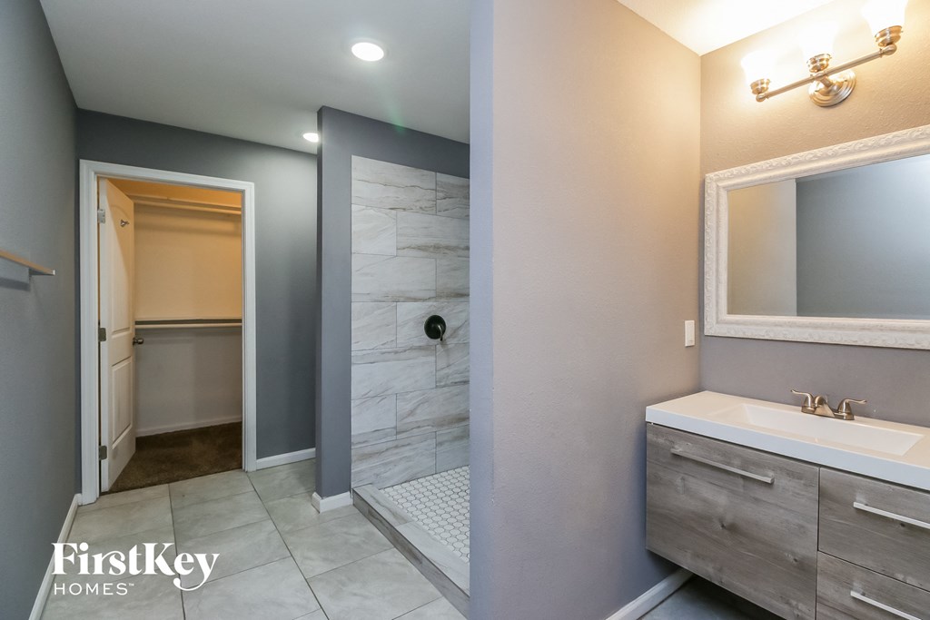 a bathroom with a shower and a sink and a mirror