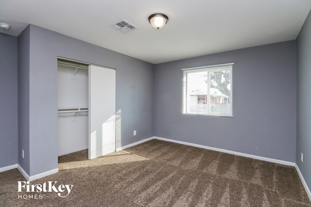 an empty room with a closet and a window