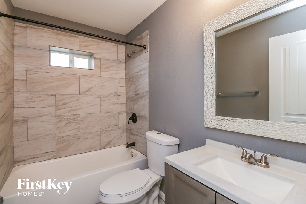 a bathroom with a shower toilet and sink and a mirror