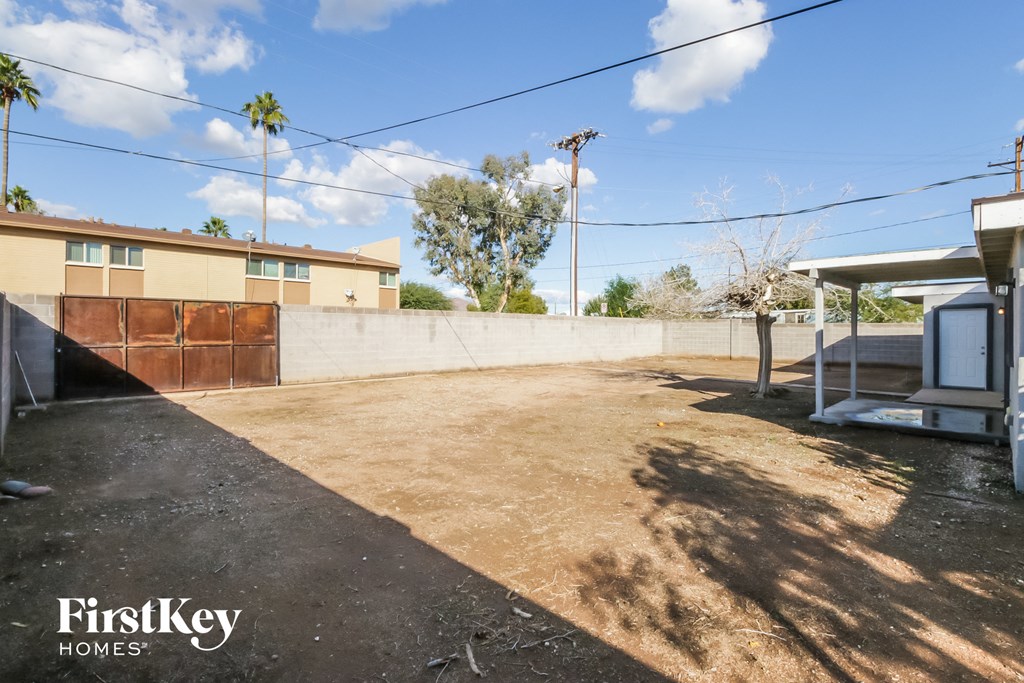 the backyard of a house with a yard and a fence