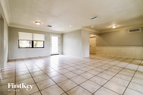 A spacious room with tile flooring and a large window.
