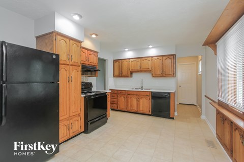A kitchen with wooden cabinets and black appliances.
