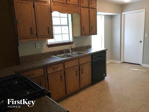 a kitchen with wooden cabinets and a sink and a window