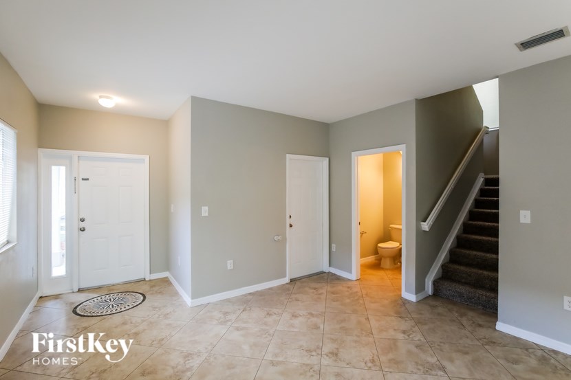 A spacious room with a staircase leading to the upper floor.