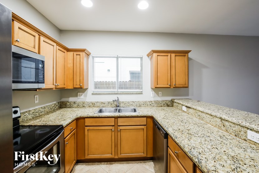 A kitchen with granite countertops and wooden cabinets.