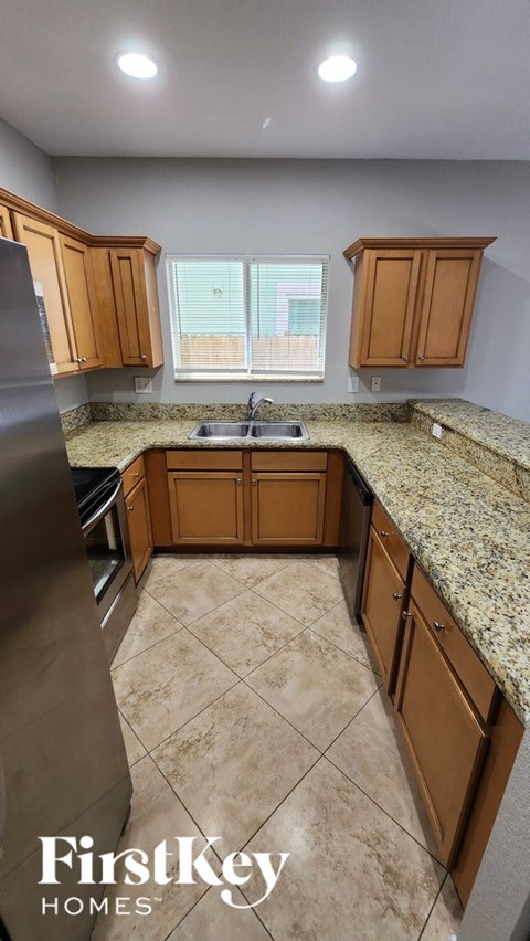 A kitchen with wooden cabinets and granite countertops.