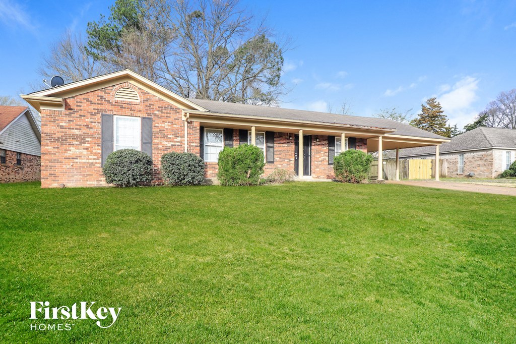 a brick house with a lawn in front of it