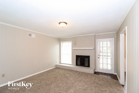 a living room with a fireplace and a carpeted floor