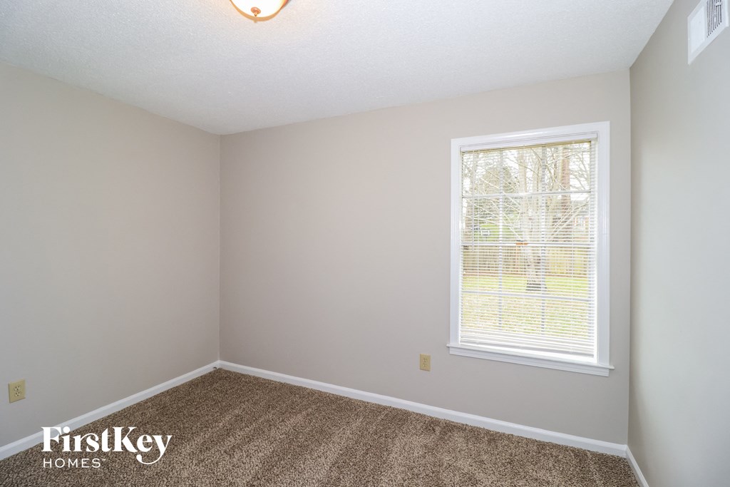 a bedroom with carpet and a window