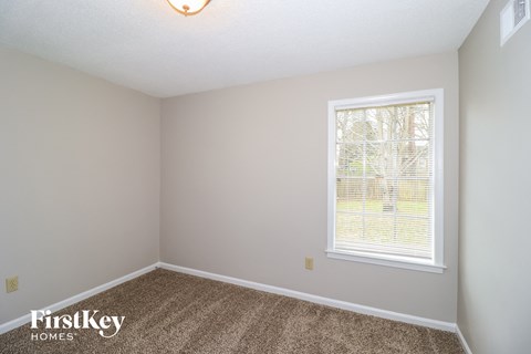 a bedroom with carpet and a window