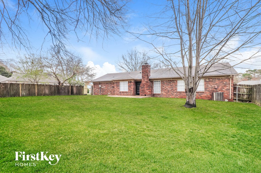 a brick house with a yard and a tree