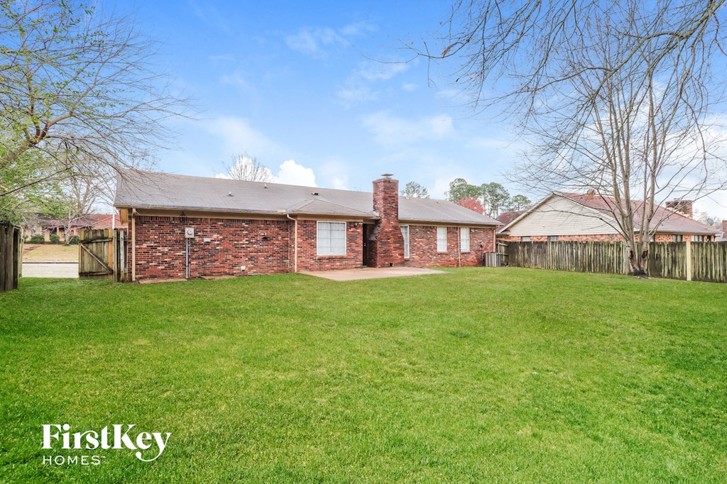 a brick house with a yard and a fence
