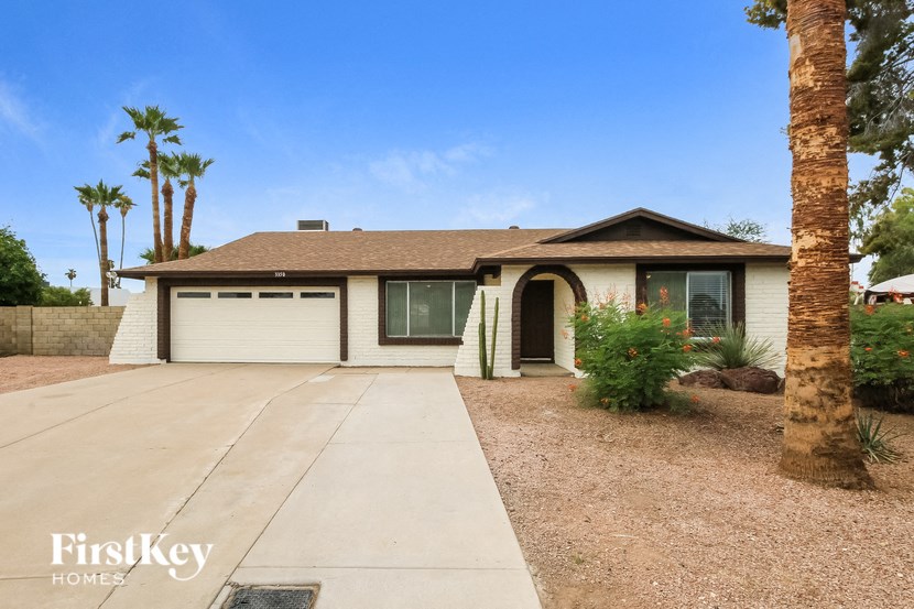 a house with a driveway and palm trees