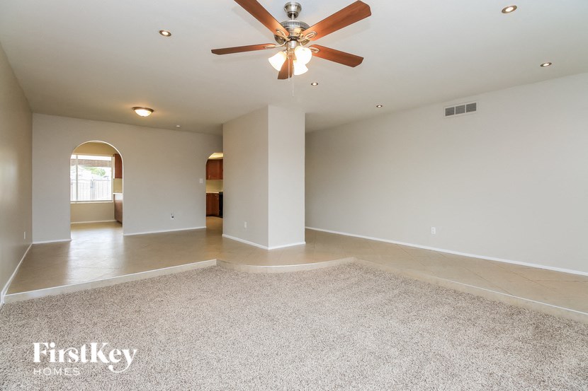 a large empty living room with a ceiling fan