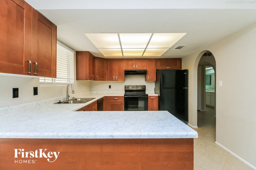 a kitchen with a marble counter top and black appliances