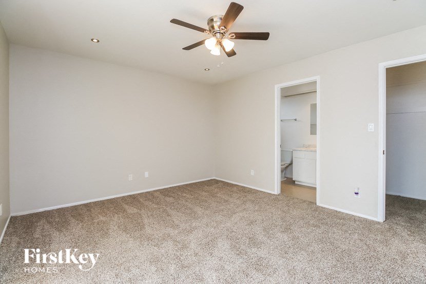 an empty living room with a ceiling fan