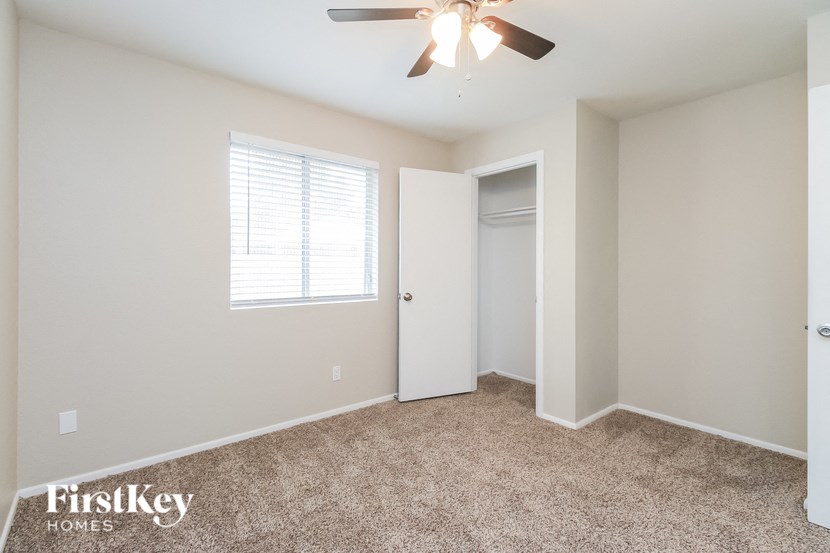 a bedroom with a ceiling fan and a closet