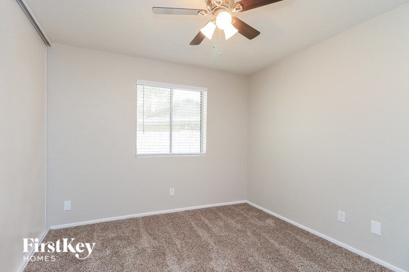 a bedroom with a ceiling fan and a window