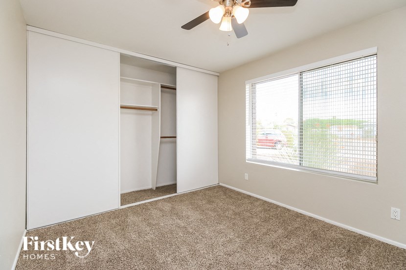 an empty bedroom with a large window and a closet