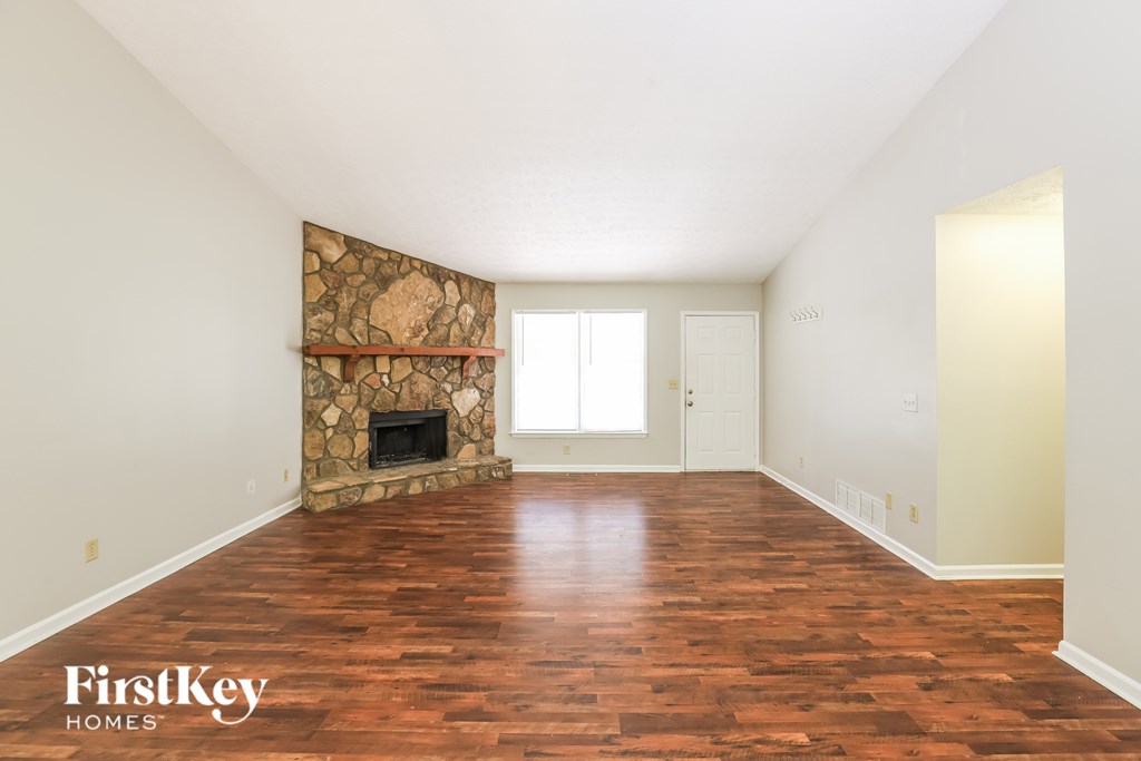 A room with a fireplace and wooden floors.