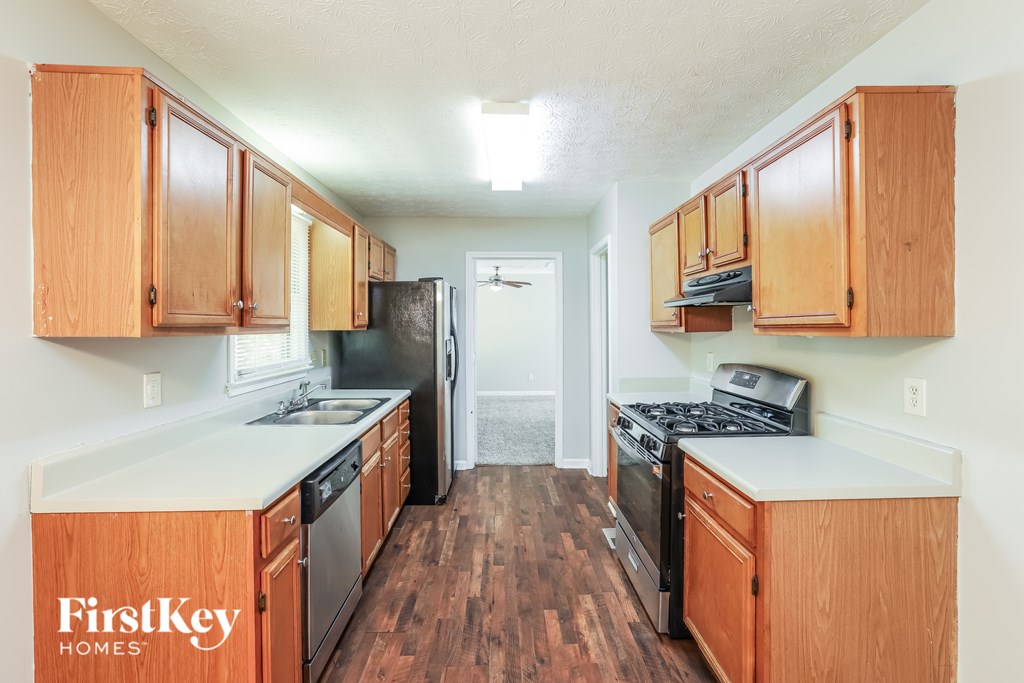 A kitchen with wooden cabinets and black appliances.