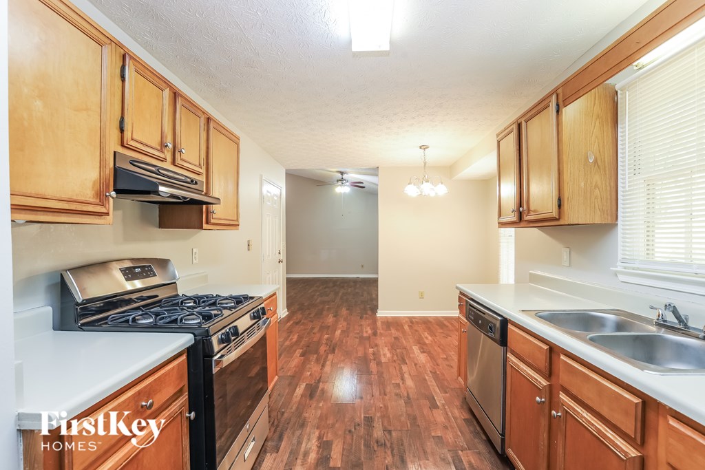 A kitchen with wooden cabinets and a stove top oven.