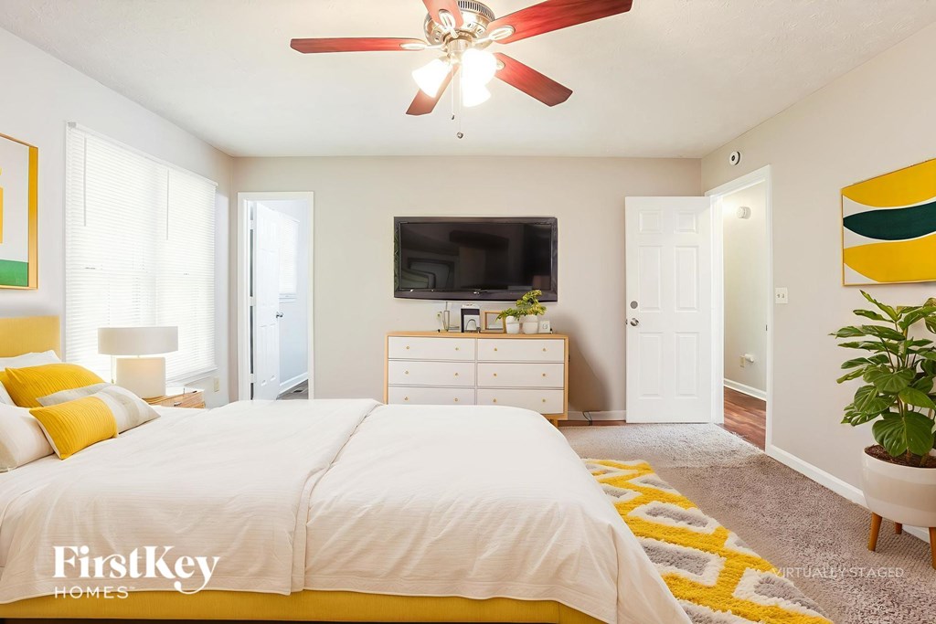 A bedroom with a bed, dresser, and television.