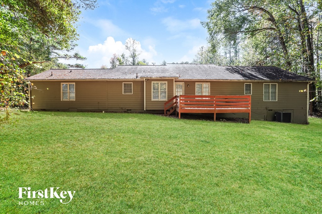 A house with a brown siding and a red bench in front of it.