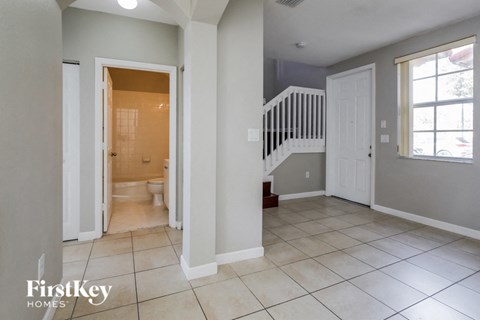 a bathroom with a white door and a staircase in a house