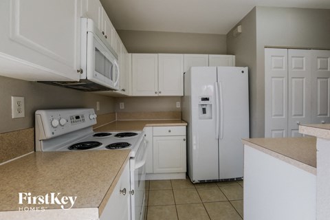 a kitchen with white appliances and a white refrigerator