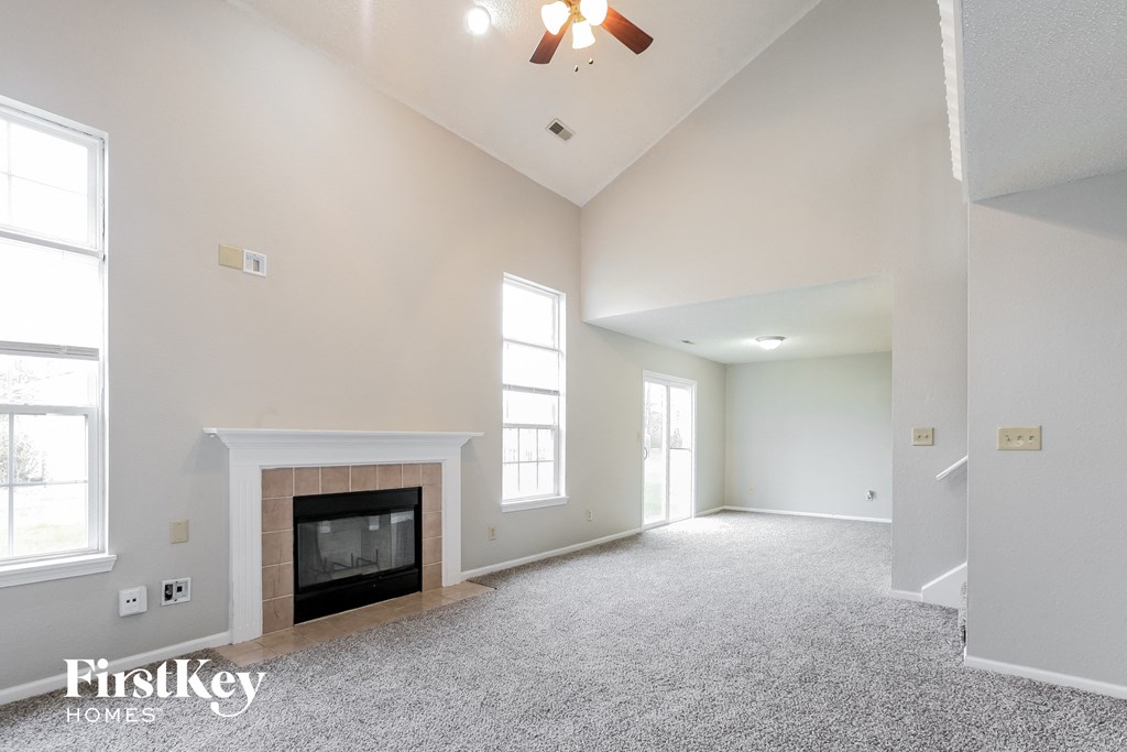 the living room of an empty house with a fireplace