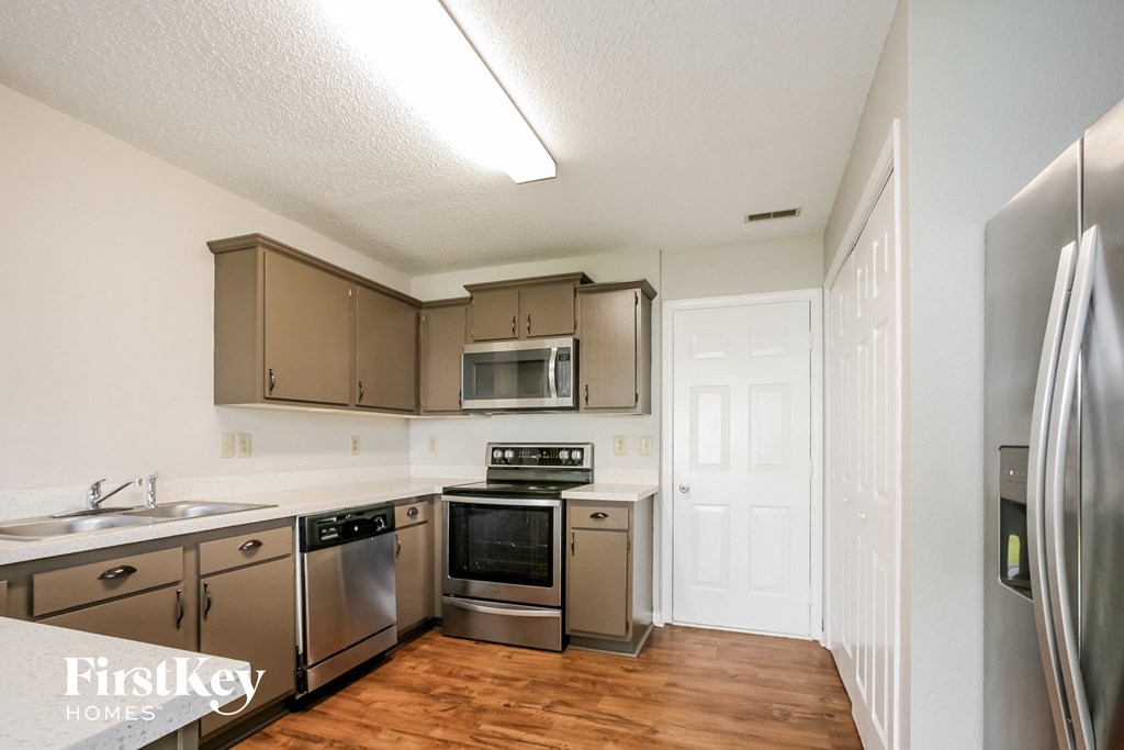 a kitchen with stainless steel appliances and a wooden floor