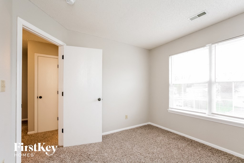 a bedroom with a large window and a closet
