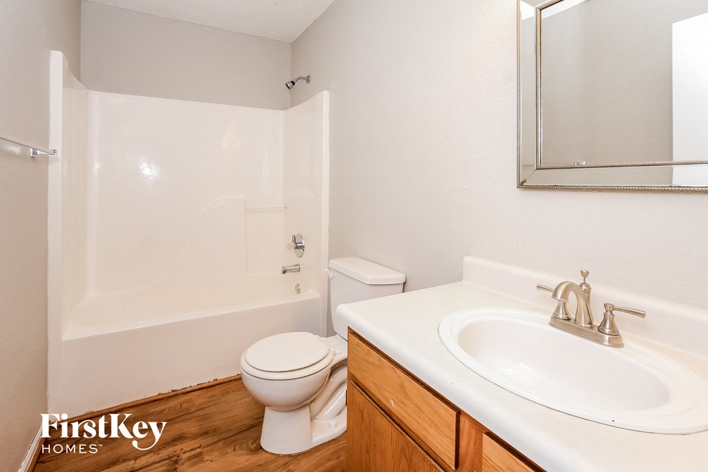 a bathroom with a sink toilet and shower and a mirror