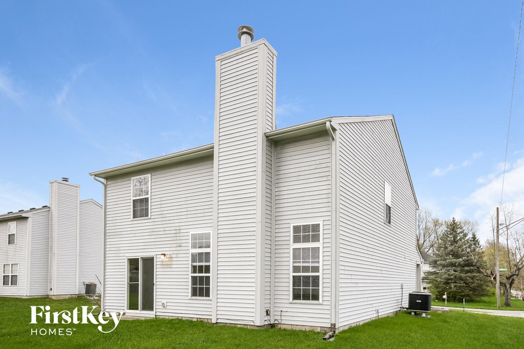 a white house with white siding and a blue sky