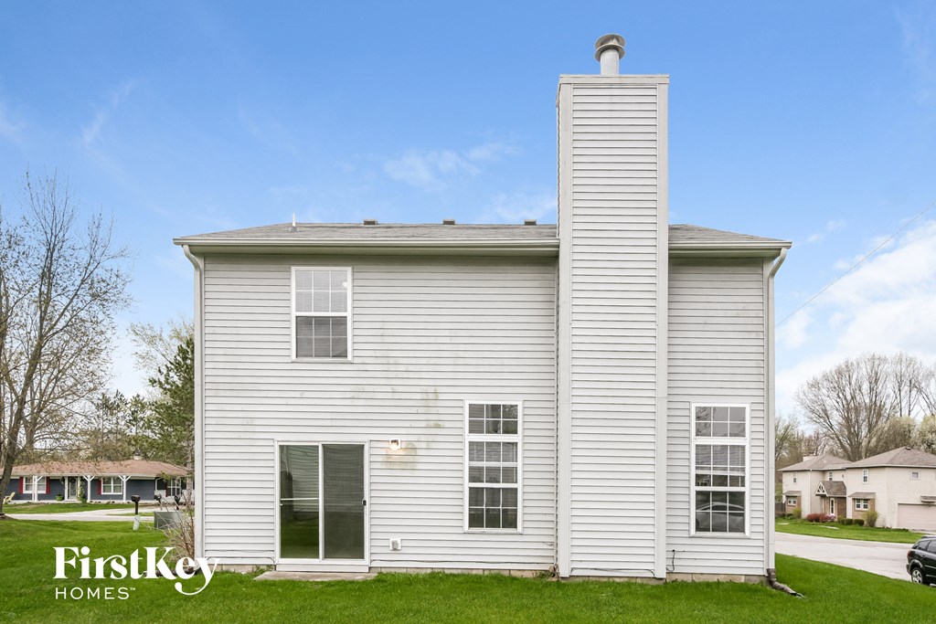 a white house with a chimney on the side of it