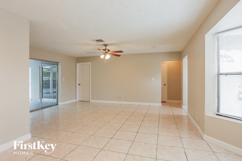 A spacious room with a ceiling fan and tiled flooring.