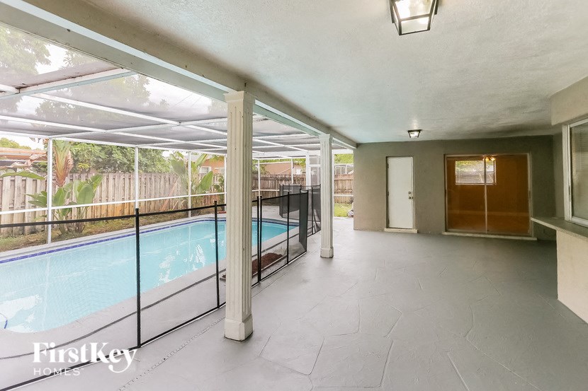 A large, empty room with a pool outside.