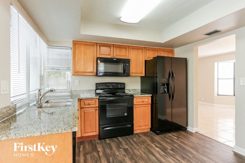 A kitchen with wooden cabinets and black appliances.