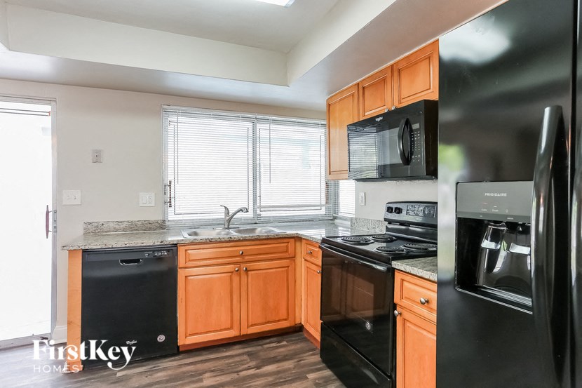 A kitchen with wooden cabinets and black appliances.