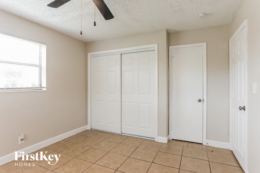 A room with a ceiling fan and two doors.