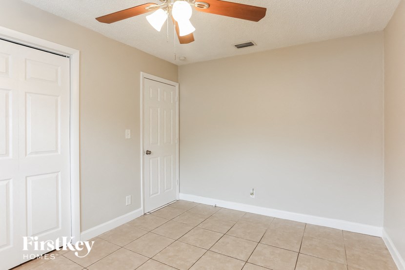 A room with a ceiling fan and two doors.